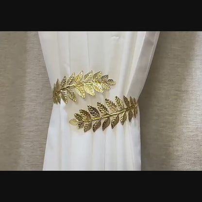 Elegantiški metaliniai užuolaidų laikikliai, laikantys baltą užuolaidą